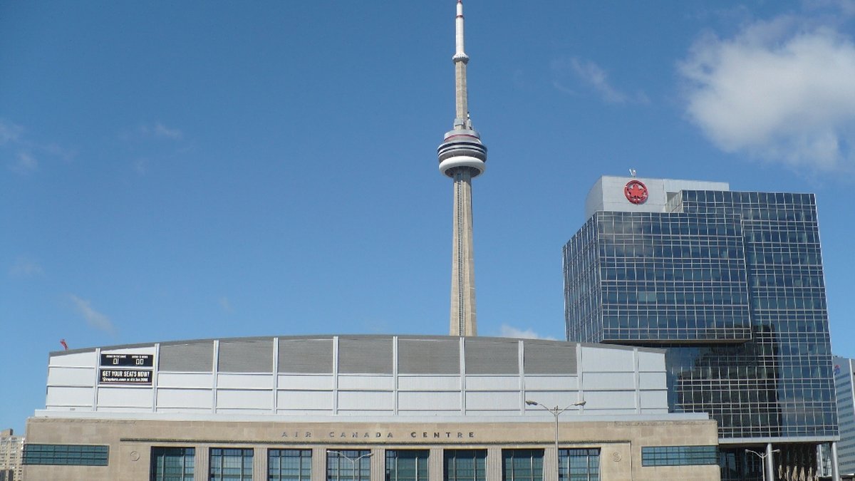 Toronto's hockey arena on Bay Street with the CN Tower rising behind it on a sunny day