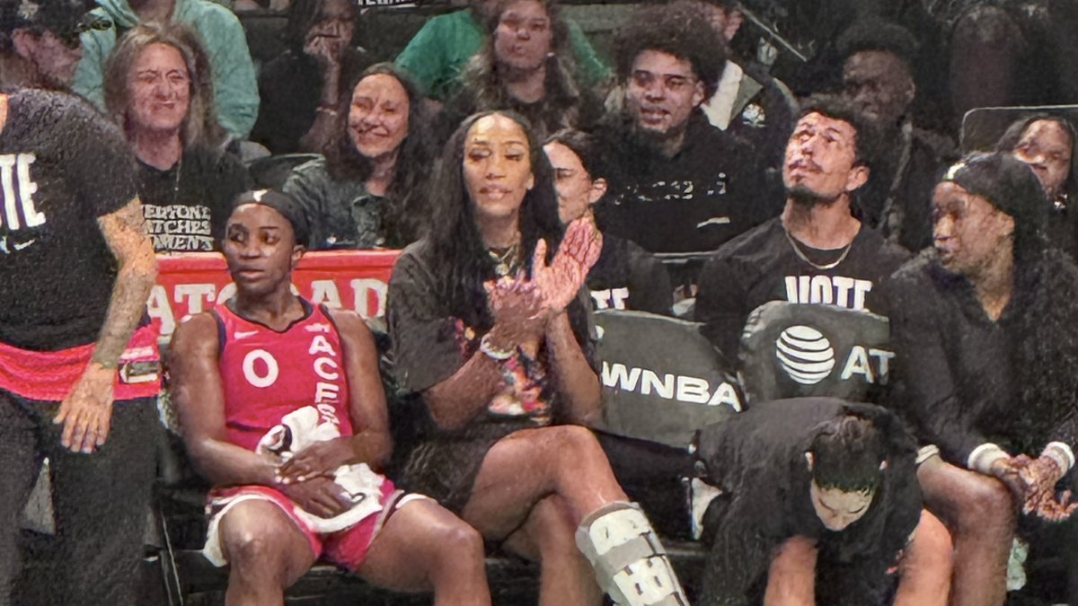 A'ja Wilson claps from the Las Vegas Aces bench next to teammate Jackie Young during a game